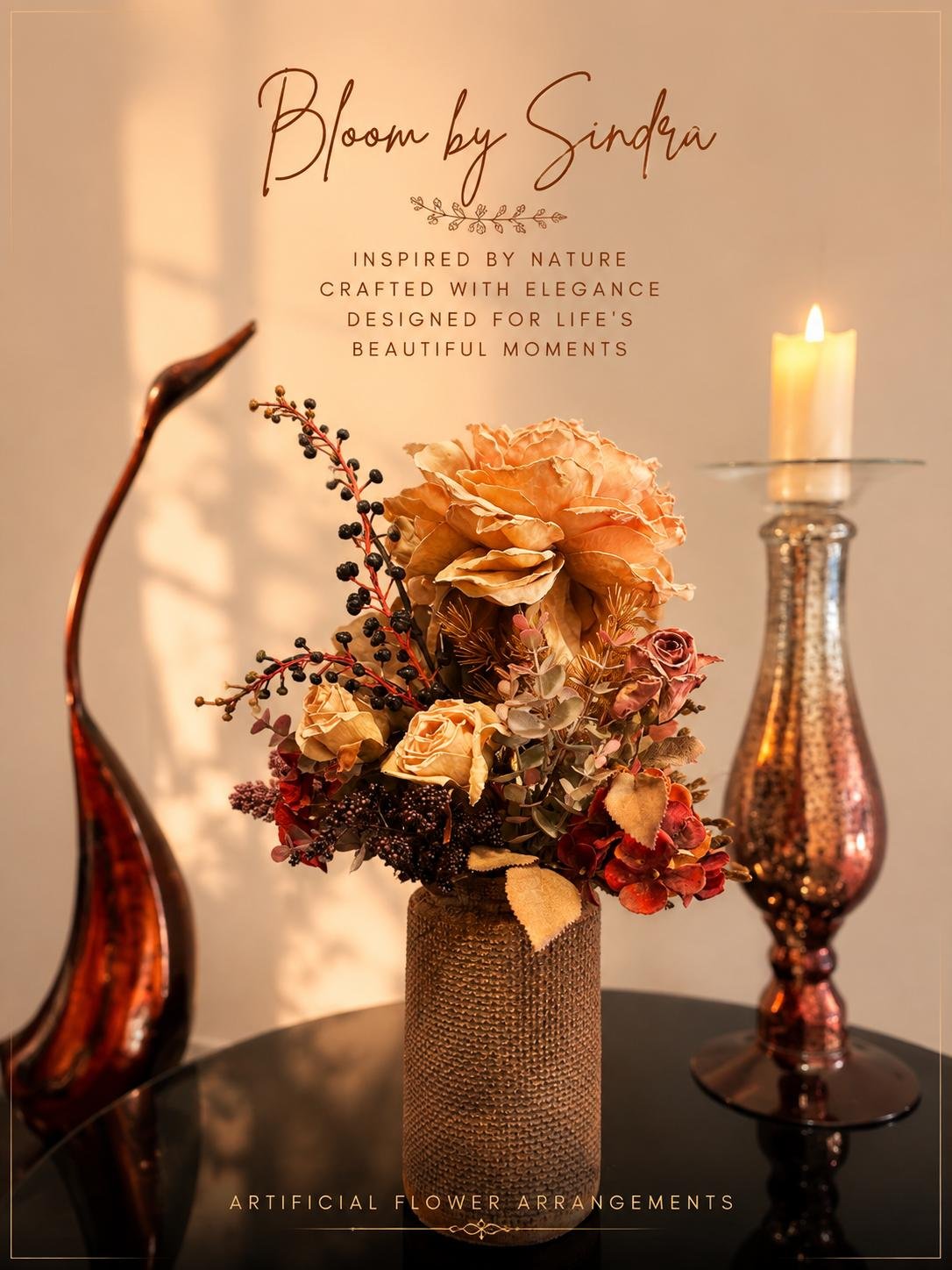 Bloom by Sindra branded photo of dried-look roses and berries in a woven vase beside a bronze crane and candle