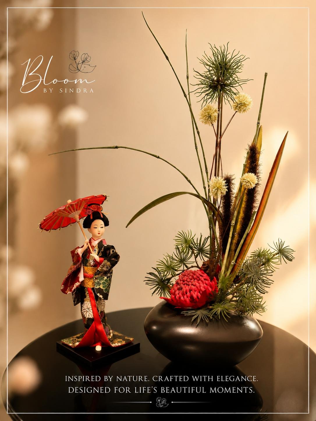 Bloom by Sindra branded photo of a black vase ikebana-style arrangement beside a traditional geisha figurine